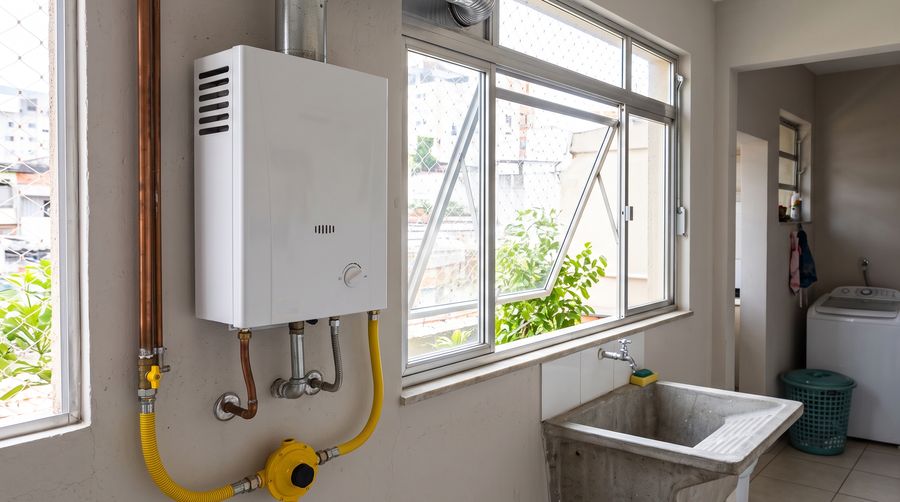 Aquecedor a gás de passagem instalado em área de serviço ventilada, com registro de gás abaixo